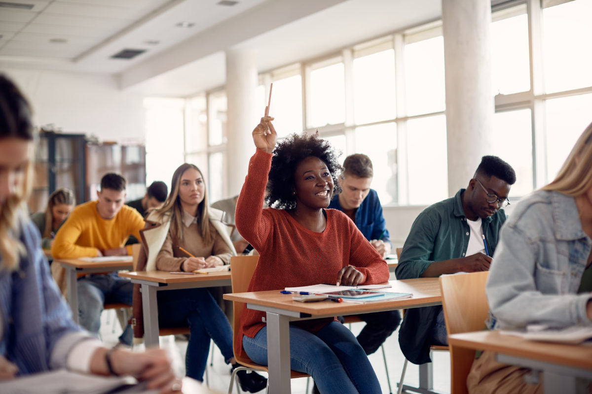 A group of people sitting at desks in a classroom.